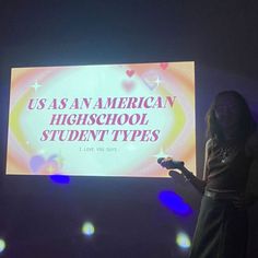 a woman standing in front of a large screen giving a speech at an american high school student types event