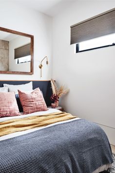 a bed sitting under a mirror in a bedroom