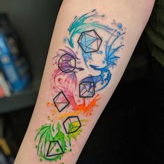 a colorful tattoo on the arm of a person's left arm, with different colored shapes