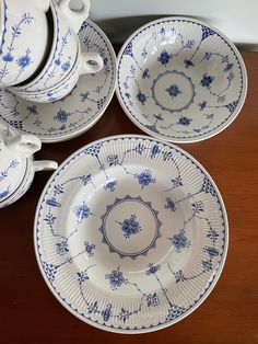 four blue and white dishes are stacked on top of each other, one is empty