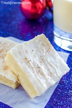 two pieces of cake sitting next to a glass of milk