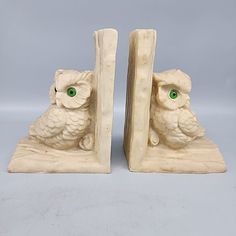 two white owl bookends with green eyes