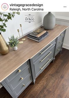 an old dresser is painted gray and gold with brass pulls on the drawers, along with some books