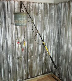 a fishing pole is attached to the side of a wooden fence