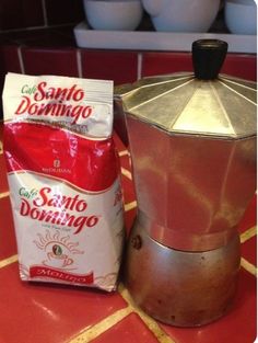 two bags of coffee sitting on top of a red counter next to a silver stove