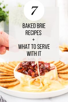 a white plate topped with crackers covered in cheese and sauce next to a hand holding a sign that says 7 baked brie recipes + what to serve with it