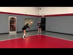 two women are playing tennis in a gym