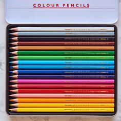 colored pencils sitting in a box on top of a white countertop with the words, color pencils written below them