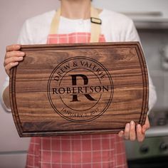 a person holding a cutting board with the name robertson on it