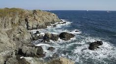 an ocean view with waves crashing on the rocks