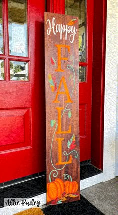 a wooden sign that says happy fall with pumpkins in front of it on the door