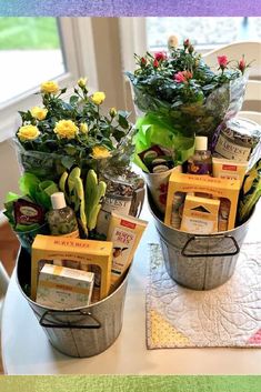 two buckets filled with flowers sitting on top of a table next to each other