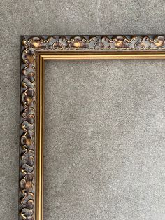 an ornate gold frame sitting on the ground