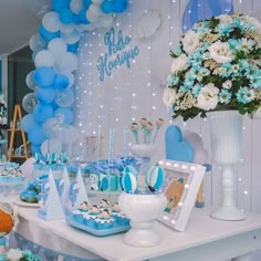 a table topped with blue and white desserts next to a vase filled with flowers