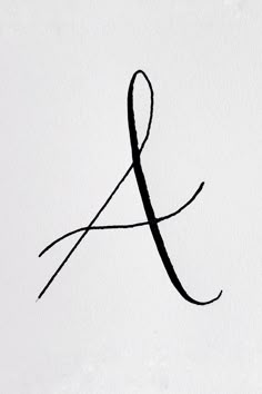 a black and white photo of the letter j in cursive writing on paper