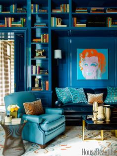 a living room filled with blue furniture and bookshelves