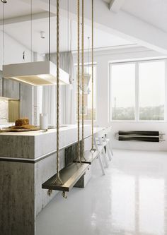 a kitchen with white walls and flooring has swings hanging from the ceiling to hold food