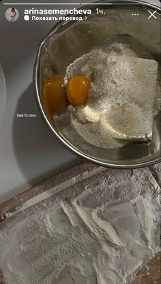 an egg is being added to flour in a bowl