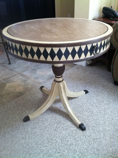 a wooden table with black and white designs on it's top sitting in a living room