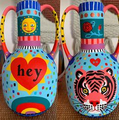 two colorful vases with designs on them, one has a tiger and the other has a heart