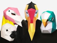 three paper birds are standing next to each other in front of a white background and one is wearing a black shirt