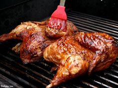 the chicken is being grilled on the grill with a brush in it's mouth