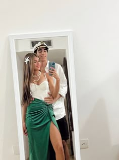 a man and woman taking a selfie in front of a mirror