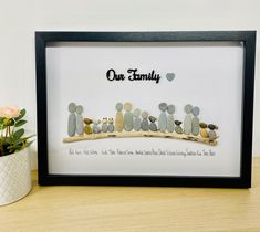 a family is made out of rocks with the words our family written on it in black frame