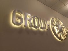 the groupex sign is lit up on the wall in front of it's logo