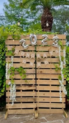 a wooden pallet sign with vines and letters on it