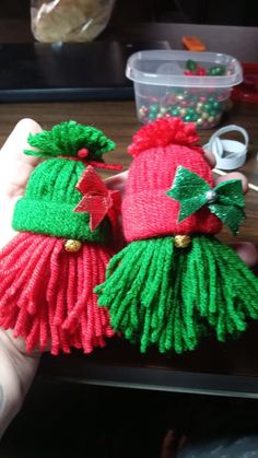 two knitted christmas hats sitting on top of a table