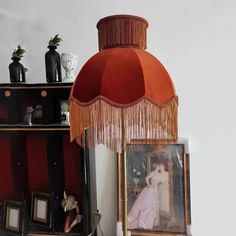 a lamp that is sitting on top of a table next to pictures and other items