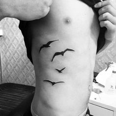 a man with birds tattoo on his stomach