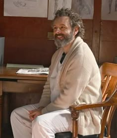 a man sitting at a desk smiling for the camera