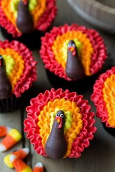 some cupcakes with chocolate frosting and candy on them that are decorated to look like a turkey