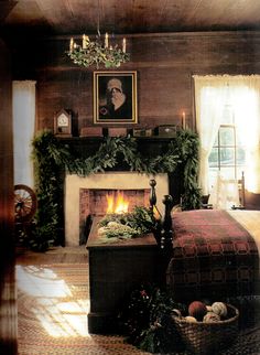 a bedroom decorated for christmas with a fireplace in the corner and pictures on the wall