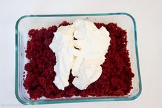 red velvet cake with cream frosting in a glass dish