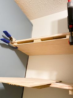 a pair of pliers are hanging on the edge of a shelf in a room