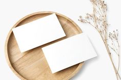 two blank cards sitting on top of a wooden plate