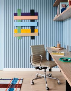 an office with a desk, chair and bookshelf on the wall in front of it