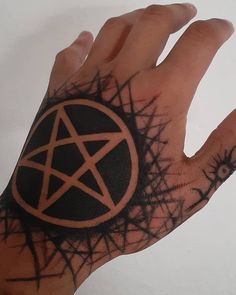 a hand with a pentagramil tattoo on it