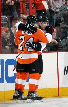 two hockey players hugging each other on the ice