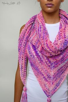 a woman wearing a pink and purple knitted shawl with tasselled ends