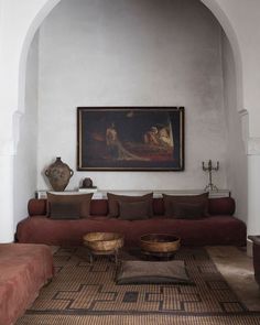 a living room filled with furniture and a painting on the wall