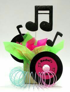 there is a cupcake with music notes on it and paper streamers in front of it