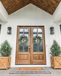 two potted plants are sitting in front of the door