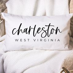 a personalized pillow that says charleston, west virginia in black on a white blanket