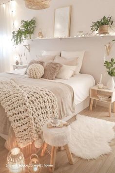 a bedroom with white walls and wooden floors is decorated in neutral tones, such as natural greenery