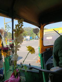 flowers are placed in a vase on the back of a bus