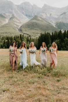 four bridesmaids walking in the mountains with their bouquets